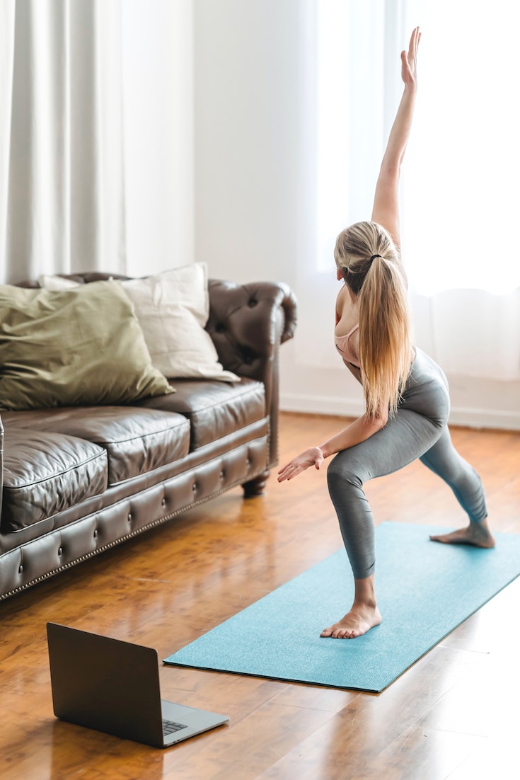 Woman working out at home on yoga mat