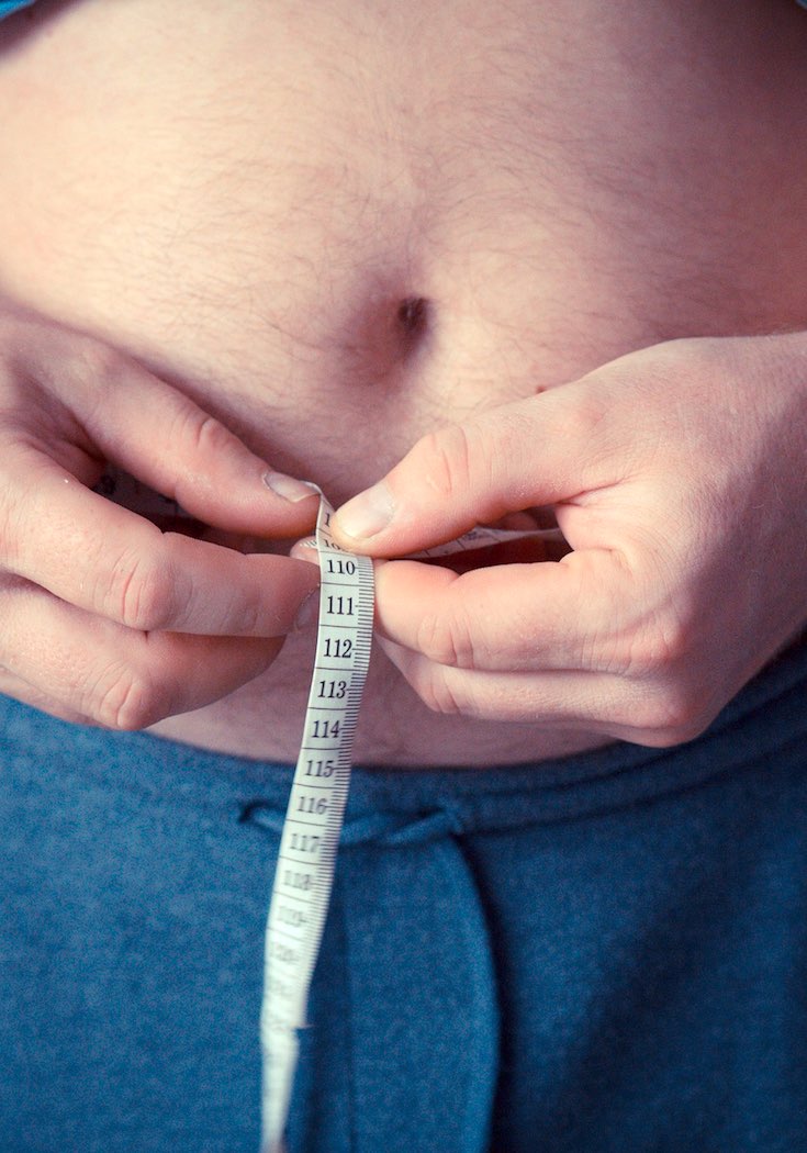 Man measuring his belly