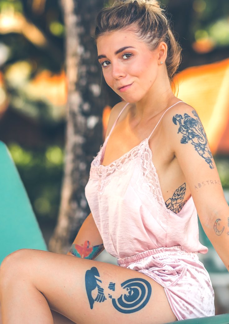 Woman with tattoos wearing pink short romper