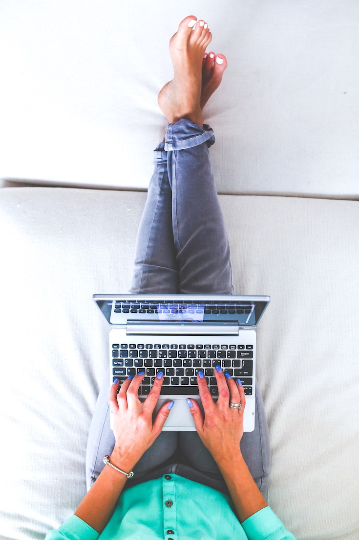 Women working remotely, lying in bed