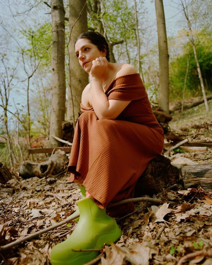 Celine Semaan Vernon in orange dress sitting in the woods
