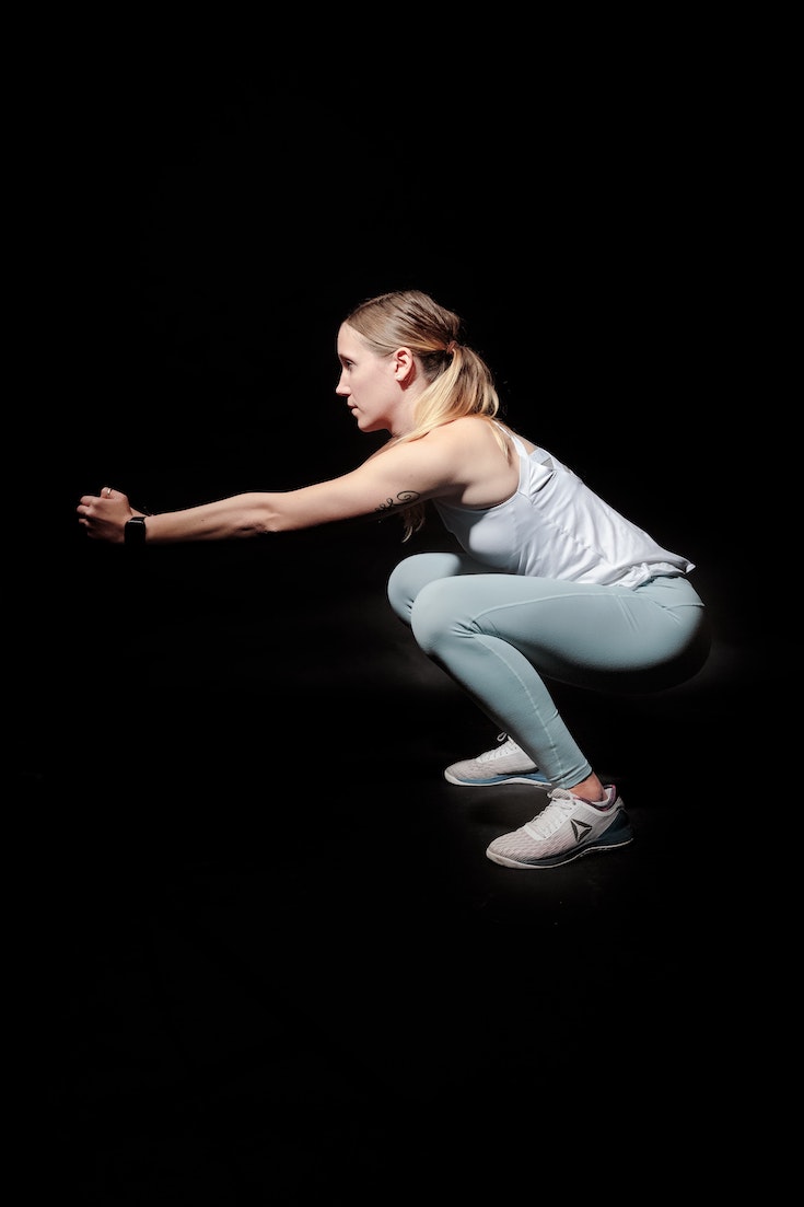 Woman performing deep squat, workout plan for the new year