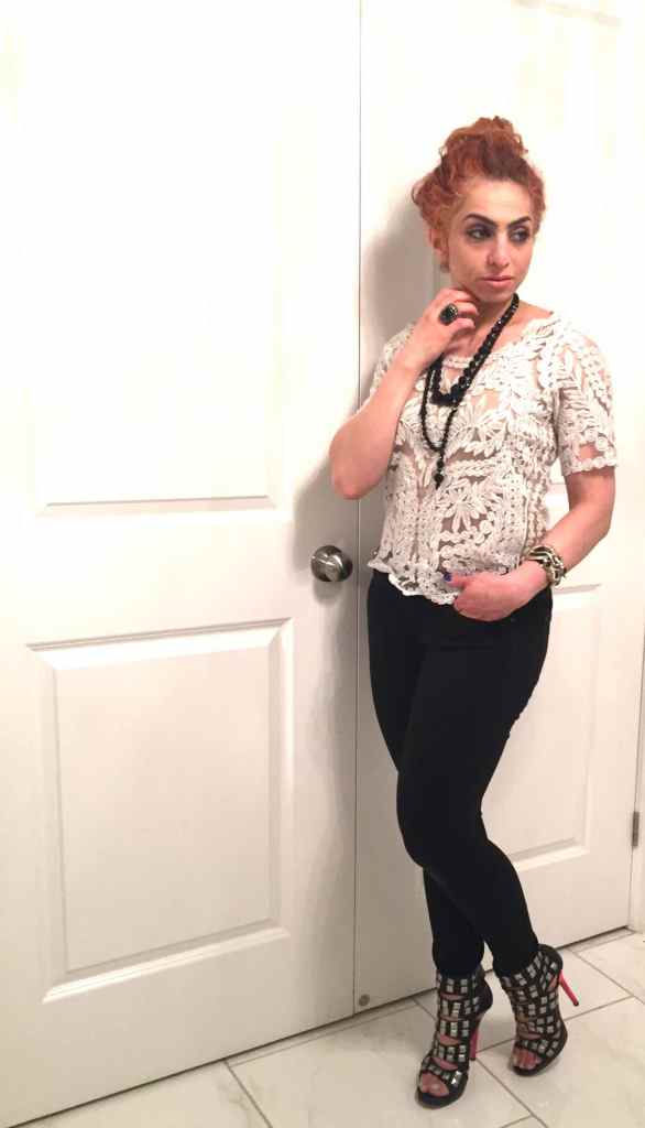 Rania in lace top with black jeans and studded bondage shoes