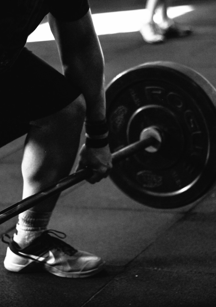 Man dead-lifting barbell with weights