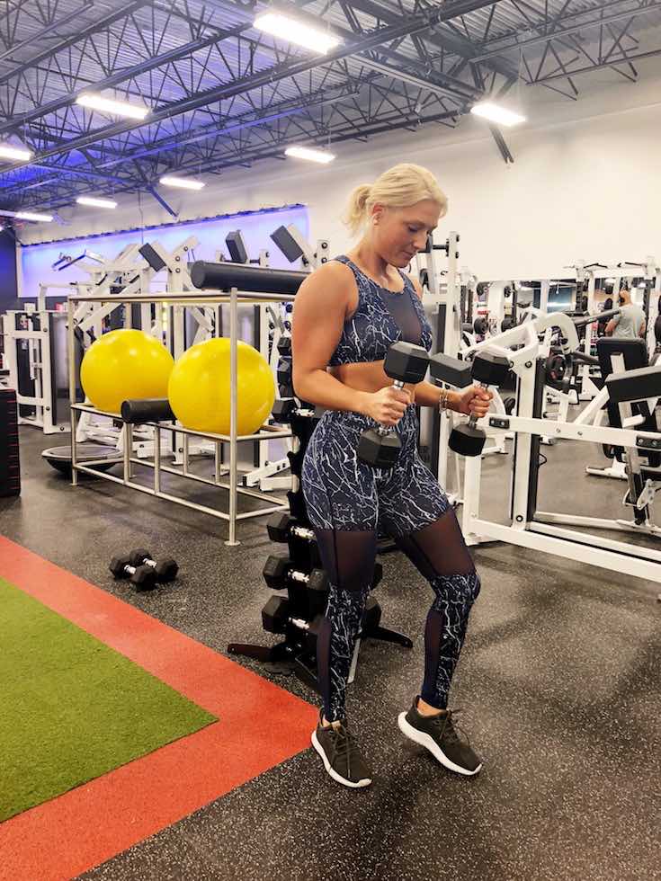 White and navy marble print workout wear, woman doing bicep curls, bikini body guide