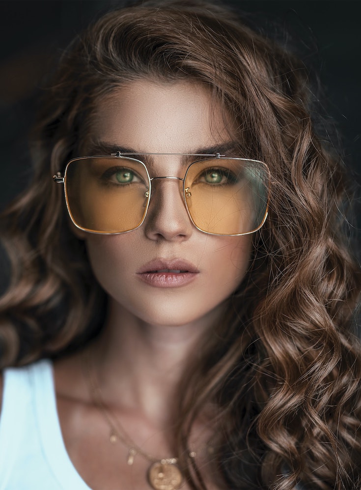 Girl with curly hear wearing large sunglasses