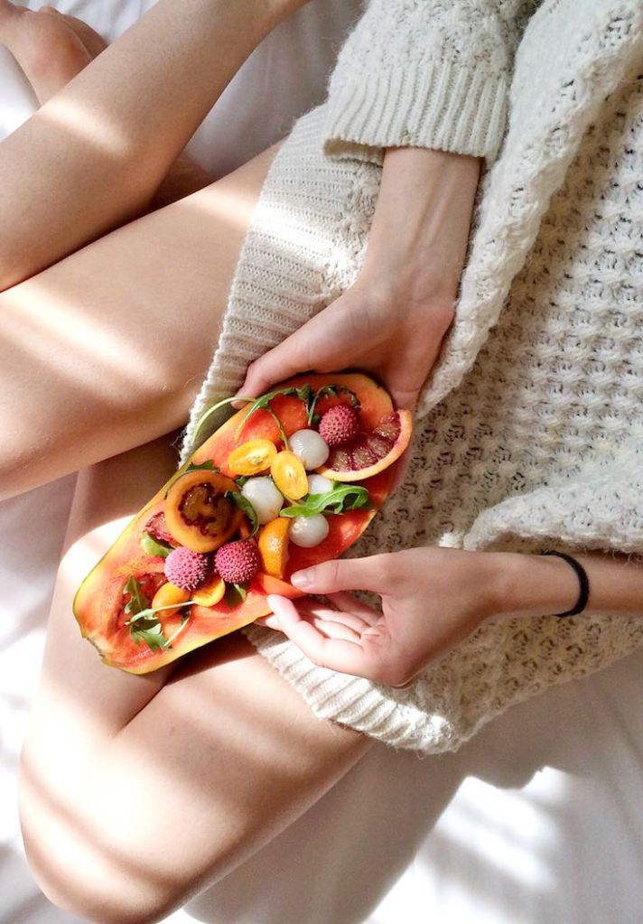 Woman eating healthy food on the bed
