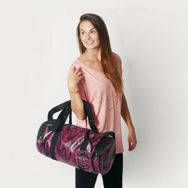 Woman holding pink and black dance bags