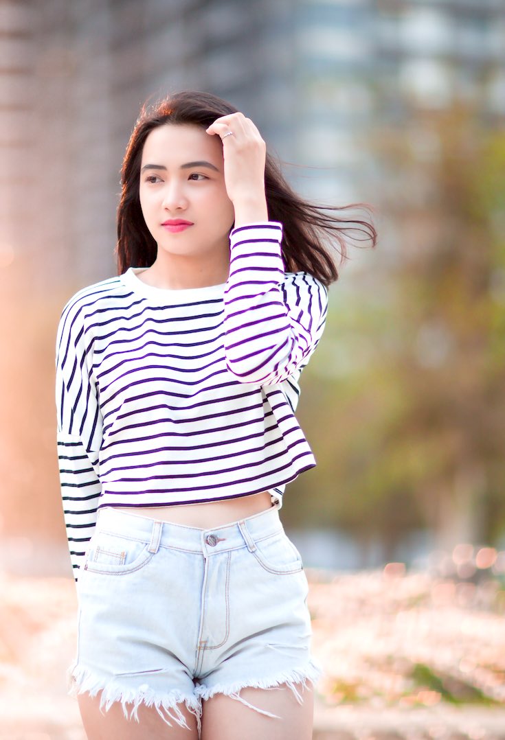 Woman wearing cut off jean shorts with striped shirt