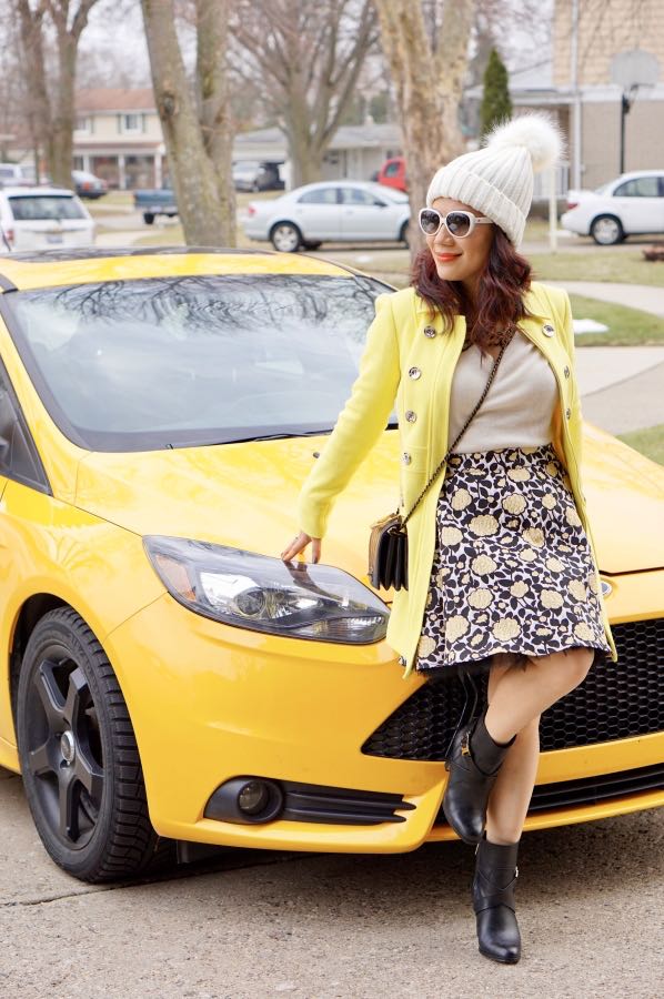 Yellow coat with cream top and floral skirt and black boots