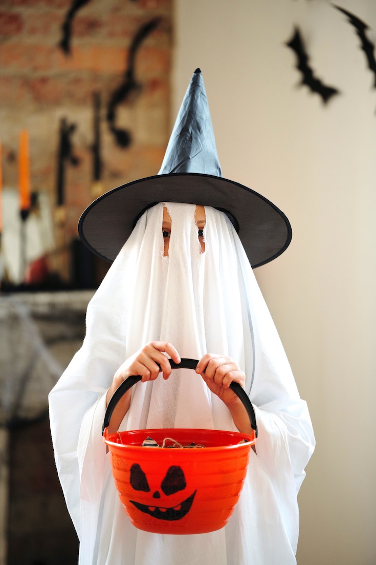Child in ghost costume trick or treating
